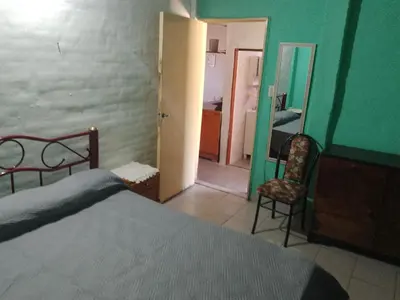 a bedroom with a bed and a door to a bathroom at Dpto Bordo in Villa Cura Brochero