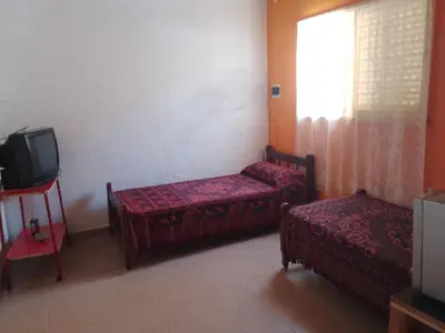 a room with two beds and a tv and a window at Dpto Bordo in Villa Cura Brochero