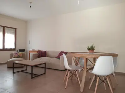a living room with a table and a couch at Casa verde - cerca Hospital Privado y Quality in Cordoba