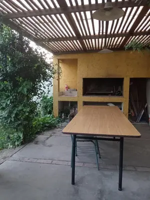 a wooden table sitting under a pergola at Casa verde - cerca Hospital Privado y Quality in Cordoba