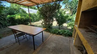 a wooden table and a chair on a patio at Casa verde - cerca Hospital Privado y Quality in Cordoba