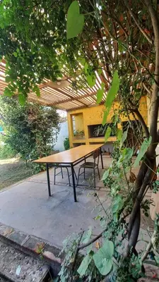 a wooden picnic table sitting under a roof at Casa verde - cerca Hospital Privado y Quality in Cordoba