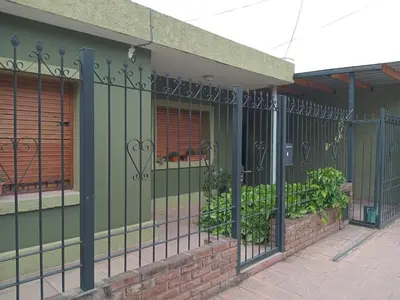 a green fence in front of a building at Casa verde - cerca Hospital Privado y Quality in Cordoba