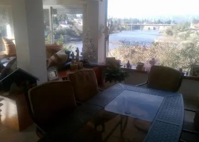a dining room table with chairs and a large window at Alquiler Temporal desde febrero in Villa Carlos Paz