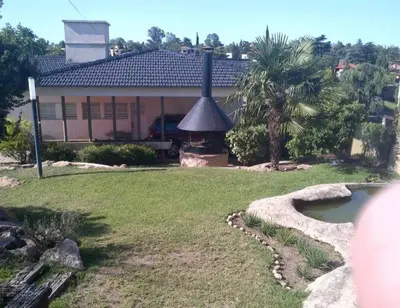 a house with a fireplace in a yard at Alquiler Temporal desde febrero in Villa Carlos Paz