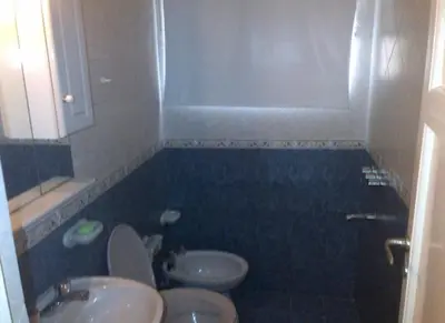 a bathroom with a toilet and a sink and a mirror at Alquiler Temporal desde febrero in Villa Carlos Paz