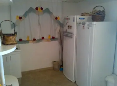 a kitchen with a white refrigerator and a window at Alquiler Temporal desde febrero in Villa Carlos Paz