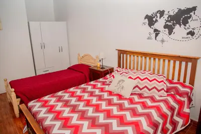 a bedroom with a bed with a red and white blanket at Casa Ezequiel in Villa Cura Brochero