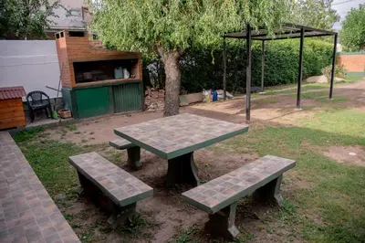 a picnic table and two benches in a park at Casa Ezequiel in Villa Cura Brochero