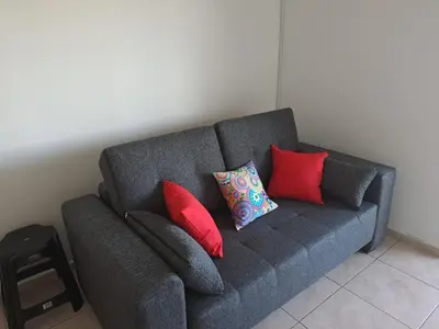a gray couch with four pillows on it at Lugones Park View in Cordoba