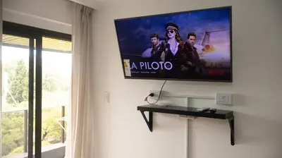 a flat screen tv hanging on a wall in a room at Lugones Park View in Cordoba