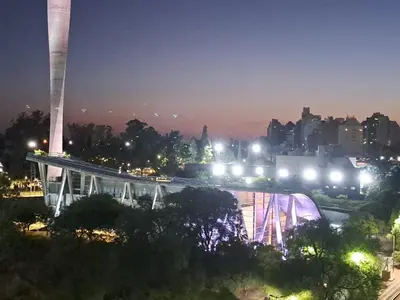 a view of a city at night with a bridge at Lugones Park View in Cordoba