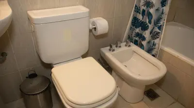 a bathroom with a white toilet and a sink at Lugones Park View in Cordoba