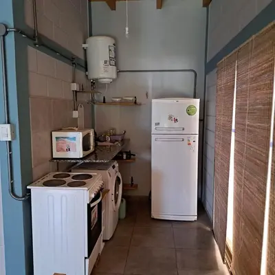 a small kitchen with a stove and a refrigerator at Departamento Interno, Barrio Universidad in Río Cuarto