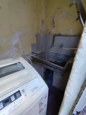 a dirty kitchen with a sink and a washing machine at Salguero Centric Apartament D4 in Cordoba