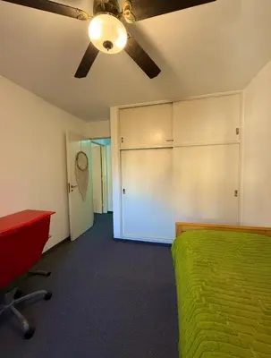 a bedroom with a green bed and a ceiling fan at Cordoba, estadio Kempes, Cerro de las Rosas, Urca, Chateau, Siglo21, Aeropuerto in Cordoba