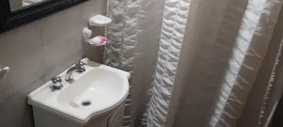 a bathroom with a white sink and a mirror at Cabaña Inti Huafi in Arroyo de Los Patos