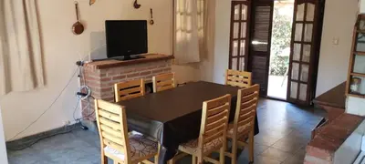 a dining room with a table and chairs and a television at Cabaña Inti Huafi in Arroyo de Los Patos