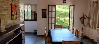 a bedroom with a bed in a room with windows at Cabaña Inti Huafi in Arroyo de Los Patos