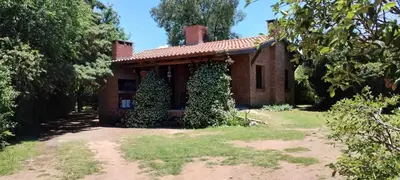 a small brick house with ivy growing on it at Cabaña Inti Huafi in Arroyo de Los Patos