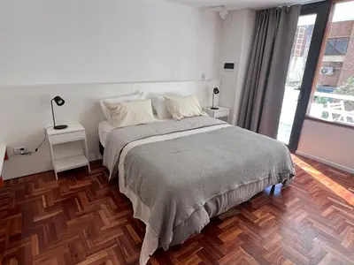 a bedroom with a bed and a large window at Departamento Orange - Piso 3 Laprida Once in Cordoba