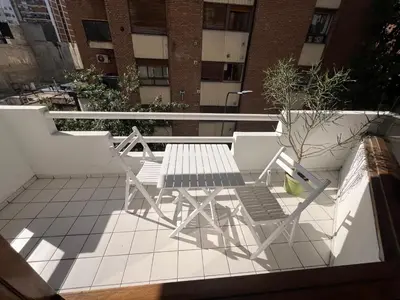 a table and chairs sitting on a balcony at Departamento Orange - Piso 3 Laprida Once in Cordoba