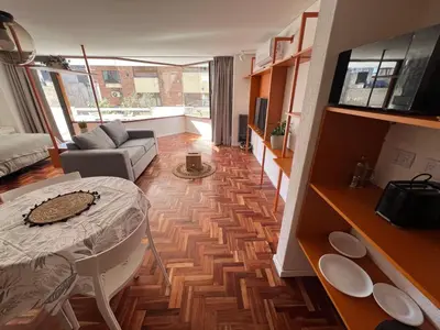 a living room with a table and a couch at Departamento Orange - Piso 3 Laprida Once in Cordoba