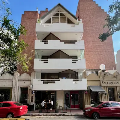 a building on the corner of a street with parked cars at Departamento Orange - Piso 3 Laprida Once in Cordoba