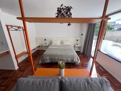a bedroom with a bed and a large window at Departamento Orange - Piso 3 Laprida Once in Cordoba