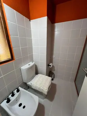 a bathroom with a white toilet and a sink at Departamento Orange - Piso 3 Laprida Once in Cordoba