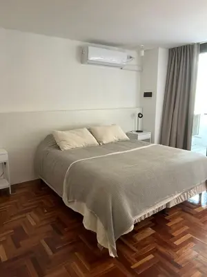 a bedroom with a large bed with a wooden floor at Departamento Red - Piso 2 Laprida Once in Cordoba