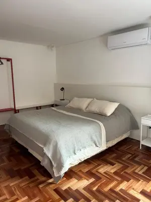 a bedroom with a bed and a wooden floor at Departamento Red - Piso 2 Laprida Once in Cordoba