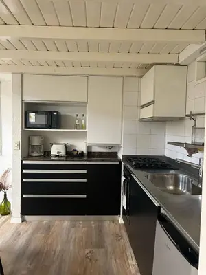 a kitchen with black and white cabinets and a sink at Departamento Duplex - Piso 4 Laprida Once in Cordoba
