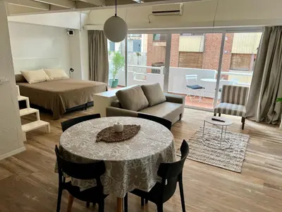 a living room with a bed and a table and chairs at Departamento Duplex - Piso 4 Laprida Once in Cordoba