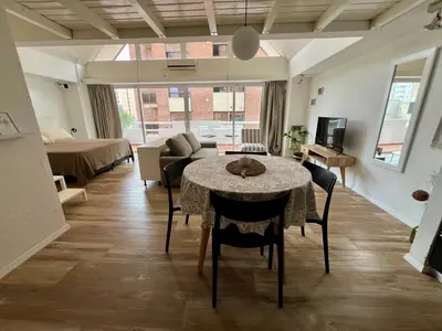 a living room with a table with chairs and a couch at Departamento Duplex - Piso 4 Laprida Once in Cordoba