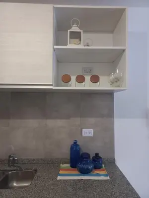 a kitchen counter with blue vases on a shelf at Apartamento Alto Alberdi in Cordoba