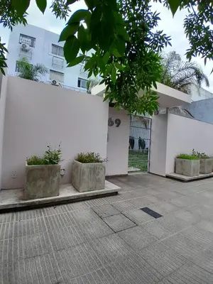 a white wall with three concrete planters in a courtyard at Apartamento Alto Alberdi in Cordoba
