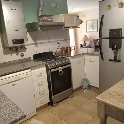 a kitchen with a stove and a refrigerator at Parques del Chateau in Cordoba