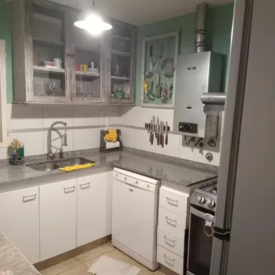 a kitchen with white cabinets and a sink at Parques del Chateau in Cordoba