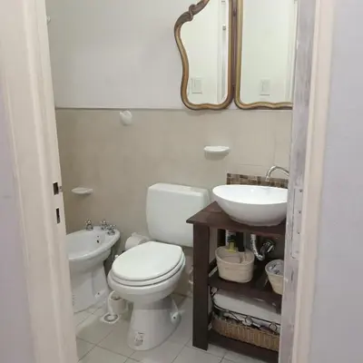 a bathroom with a toilet and a sink and a mirror at Parques del Chateau in Cordoba