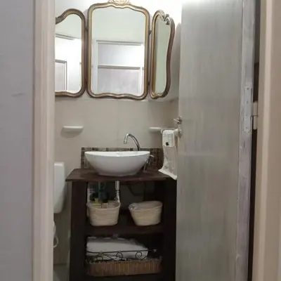 a bathroom with a sink and two mirrors at Parques del Chateau in Cordoba
