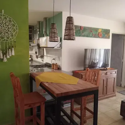 a kitchen with a wooden table and chairs in it at Parques del Chateau in Cordoba