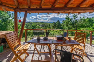 a wooden table and chairs on a deck with a view at Terracota Eco-Casa Intiyaco 6 Pax in Atos Pampa