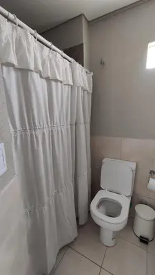 a bathroom with a toilet and a shower curtain at DeRest - Barrio General Paz in Cordoba