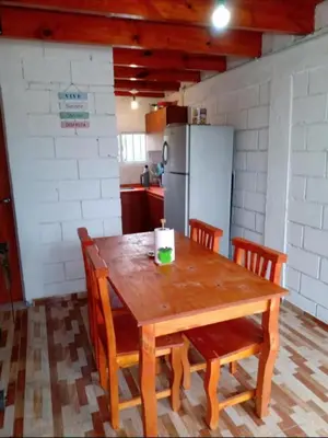 a kitchen with a wooden table with chairs and a refrigerator at Cabaña Economica en Bialet Massé a 9 km de Cosquín in Bialet Massé