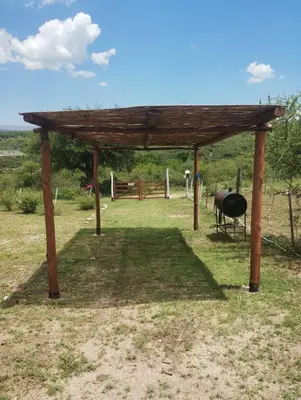 a wooden pavilion with a grill in a field at Cabaña Economica en Bialet Massé a 9 km de Cosquín in Bialet Massé