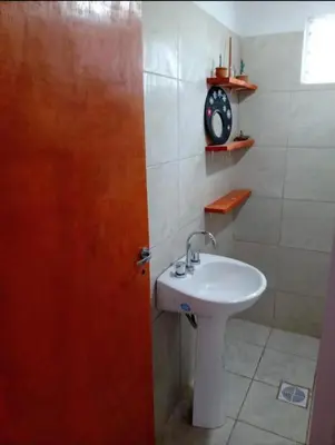 a bathroom with a sink and a clock on the wall at Cabaña Economica en Bialet Massé a 9 km de Cosquín in Bialet Massé