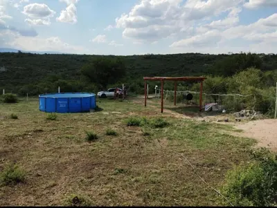 a playground in a field with a fence and a shed at Cabaña Economica en Bialet Massé a 9 km de Cosquín in Bialet Massé