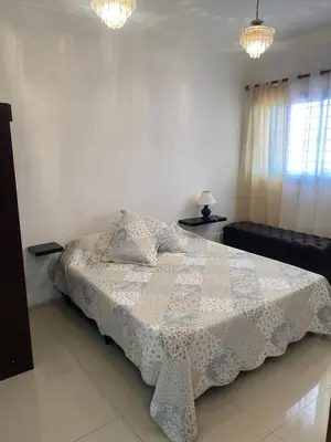 a bedroom with a bed and two tables and a window at El Búho Apart in Villa Parque Siquiman