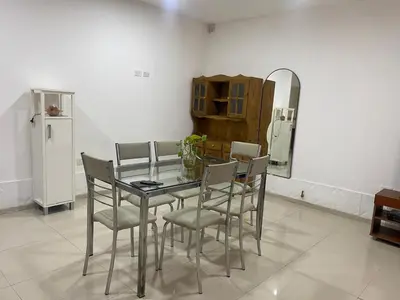 a dining room with a table and chairs and a refrigerator at El Búho Apart in Villa Parque Siquiman